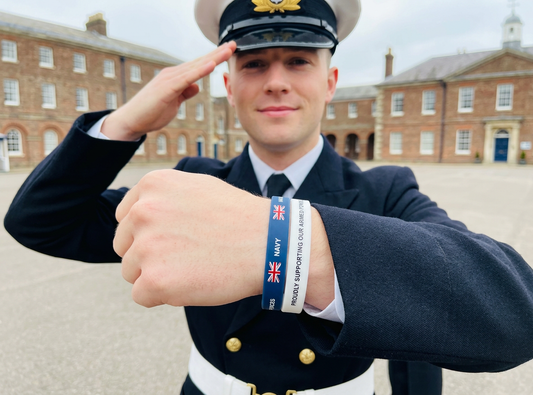 Sailor in uniform saluting, wearing a Royal Navy wristband